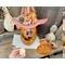 A handmade Halloween decoration, a fall gourd carved into a whimsical pumpkin. This pumpkin comes with a battery-operated candle. 